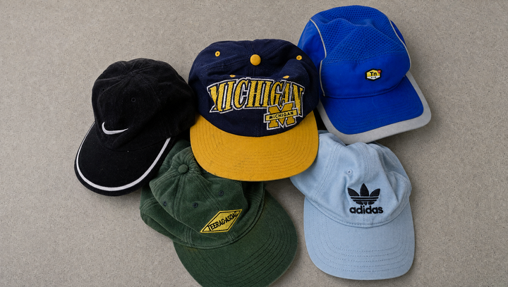 Fünf Vintage Caps auf Betonboden: Michigan Snapback, Nike TN, schwarze Nike Cord-Cap, grüne Cord-Cap und adidas Cap